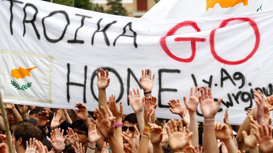 Demonstranten mit Plakat: Troika go home