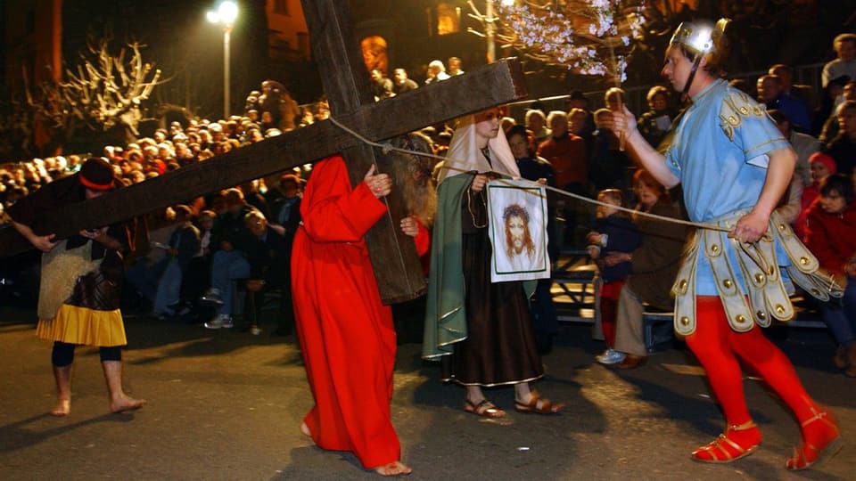 Der Darsteller von Jesus Christus trägt sein Kreuz an der Osterprozession durch die Gassten der Altstadt von Mendrisio.