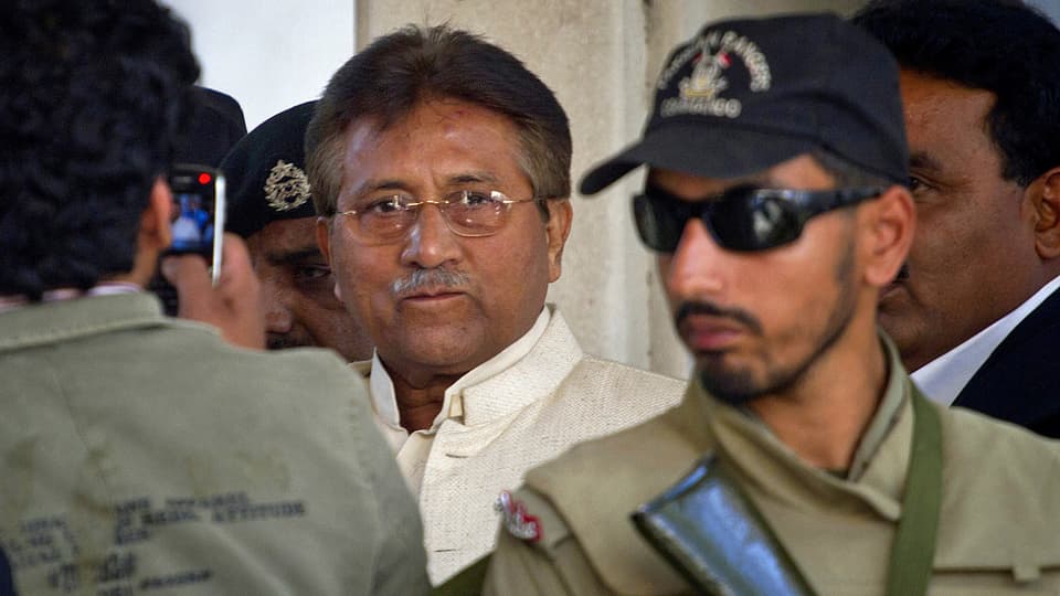 Musharraf neben Sicherheitskräften.