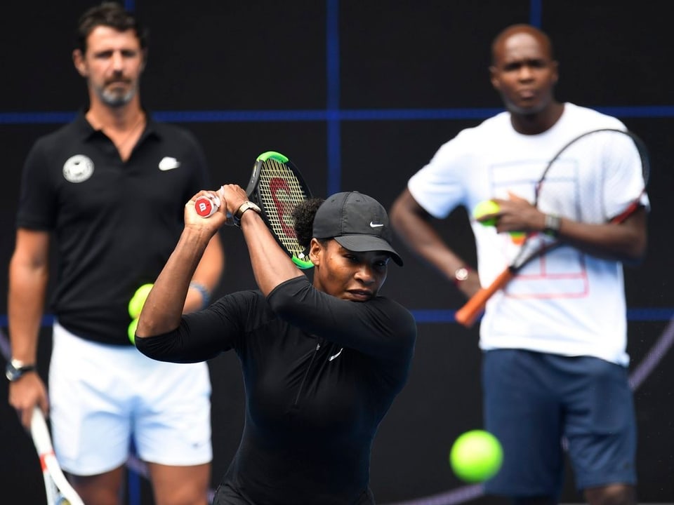 Serena Williams trainiert vor den Augen ihrer Coaches. 