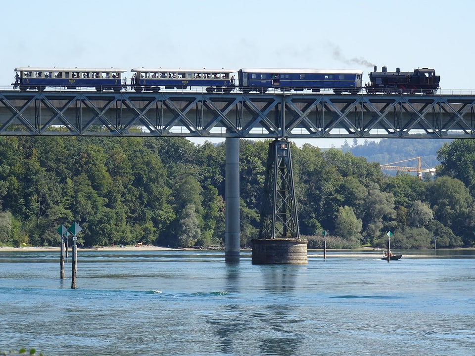 «Die Museumsbahn Etzwilen - Singen fährt über die denkmalgeschützte Rheinbrücke bei Hemishofen. Unten glitzert das Wasser.
