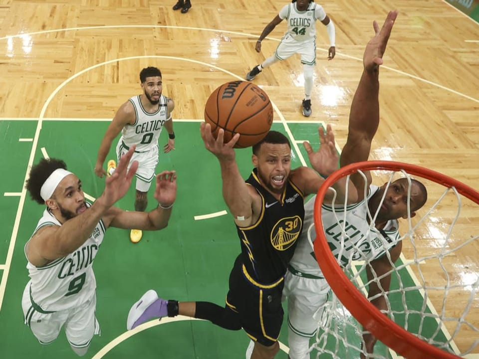 Stephen Curry setzt sich gegen 3 Celtics-Spieler durch.