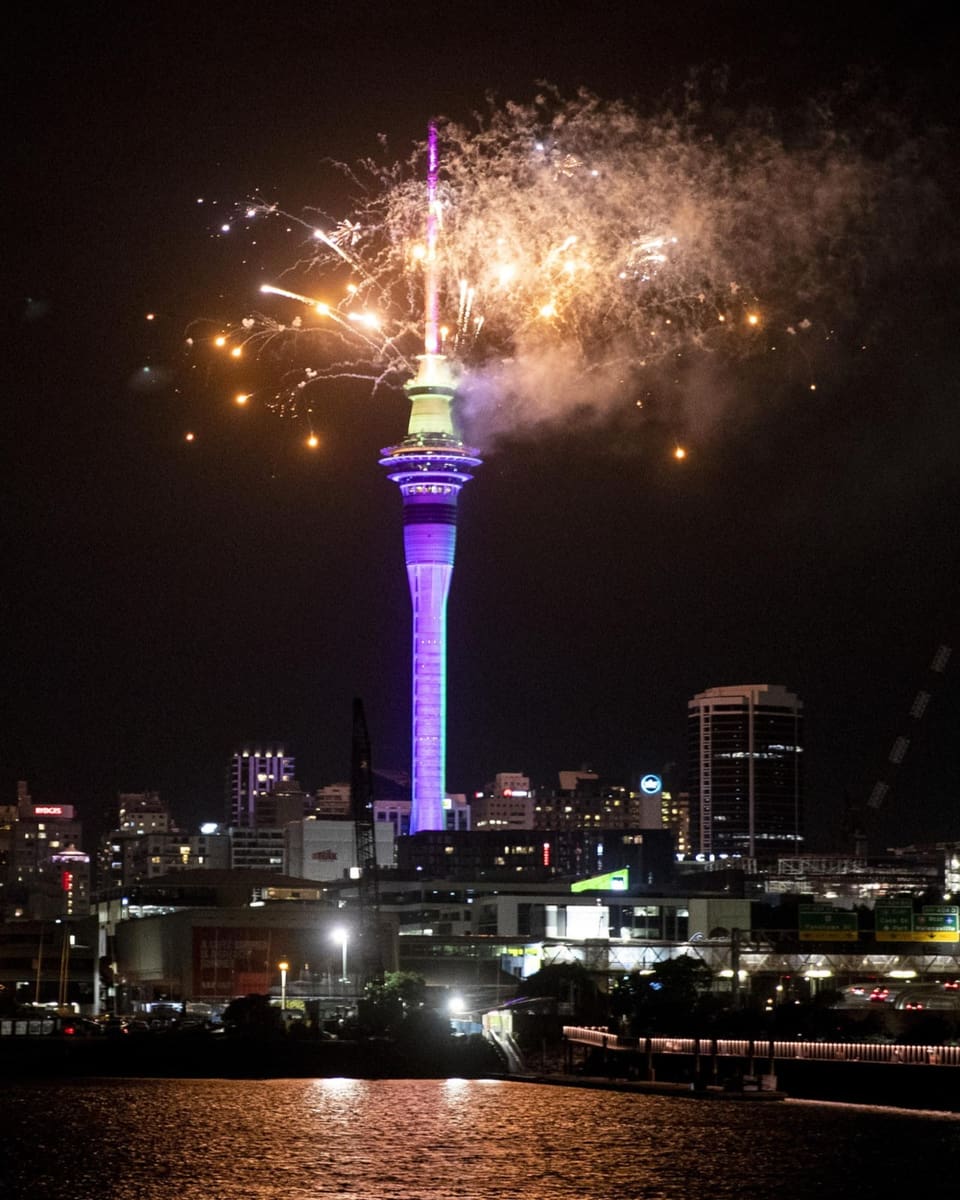 Feuerwerk explodiert über dem blau beleuchteten Turm.