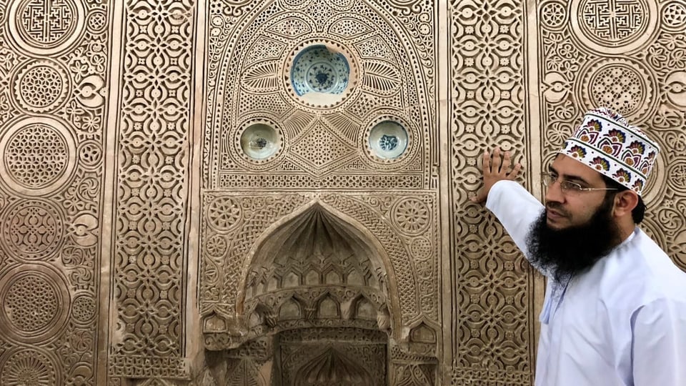 Ein Imam zeigt eine Mauer