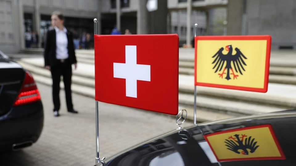Die Fahnen der Schweiz und Deutschland sind an einer Limousine befestigt. 