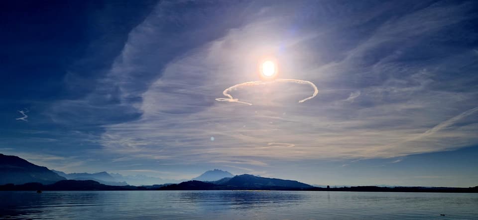 Schleierwolken mit halbkreisförmigem Kondensstreifen.