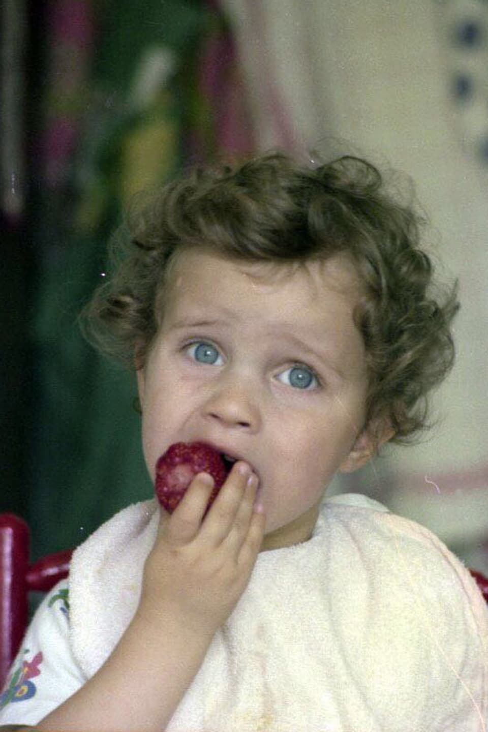 Adrian Küpfer beisst als Kind in eine Erdbeere.