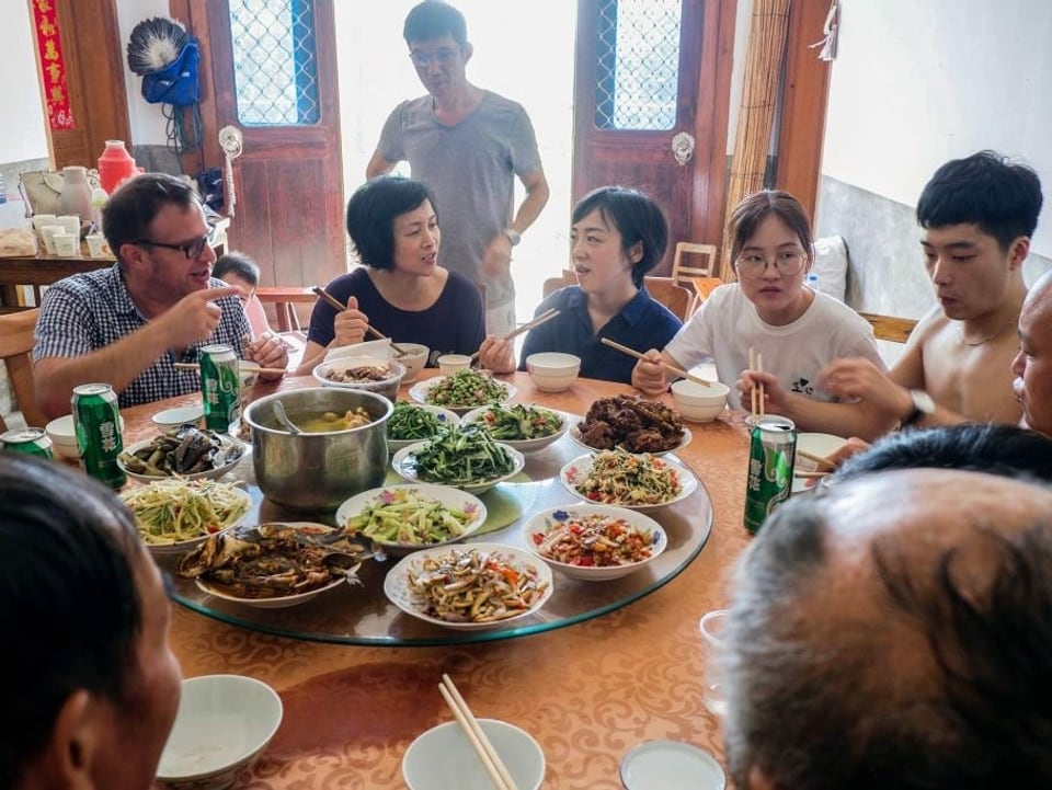Pascal Nufer am Tisch bei der Familie seiner Haushälterin Changyun Geng auf dem Land in der Provinz Anhui.