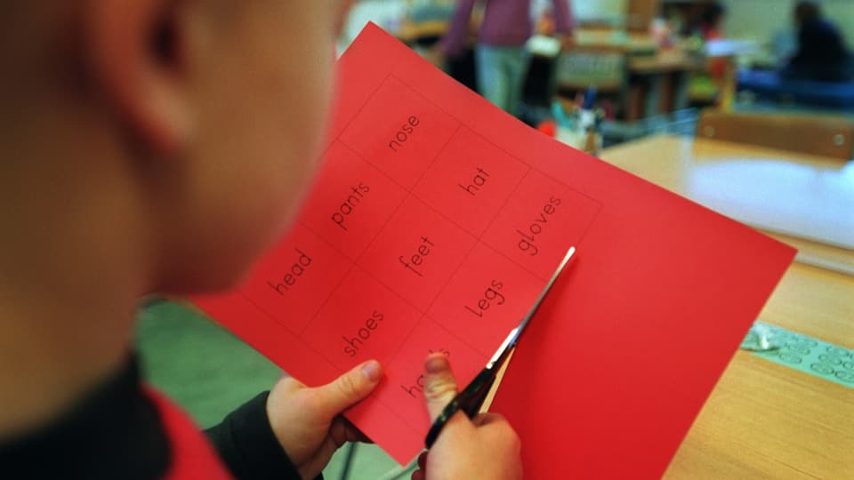 Ein Schulkind schneidet ein Papier