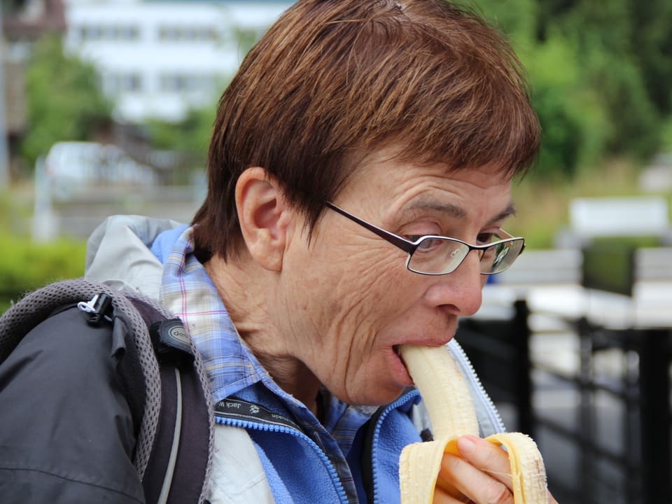 Eine Wanderin isst eine Banane.