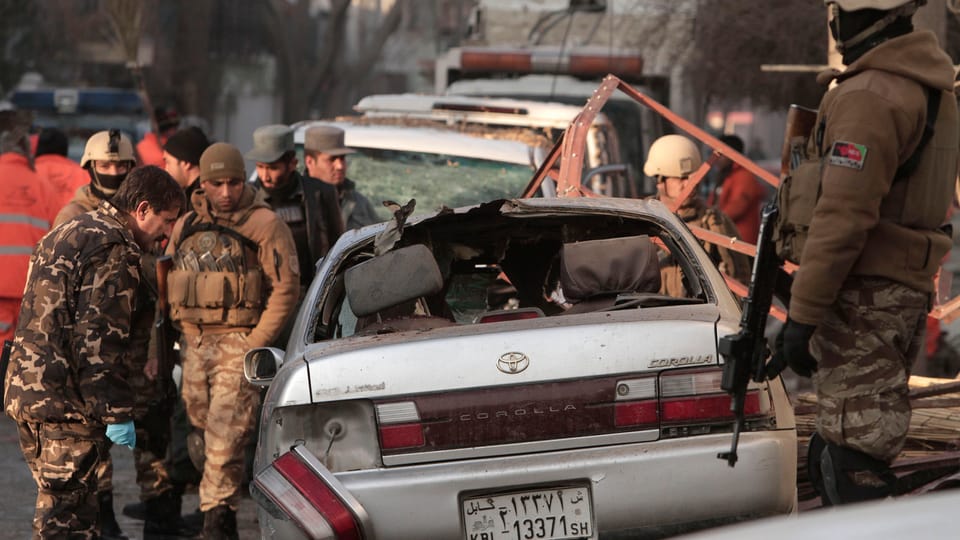 Soldaten und Spezialisten sichern den Tatort vor dem Restaurant in Kabul.