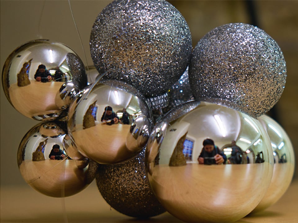 Ein Arrangement aus silbernen Weihnachtskugeln, in denen sich der Fotograf spiegelt.