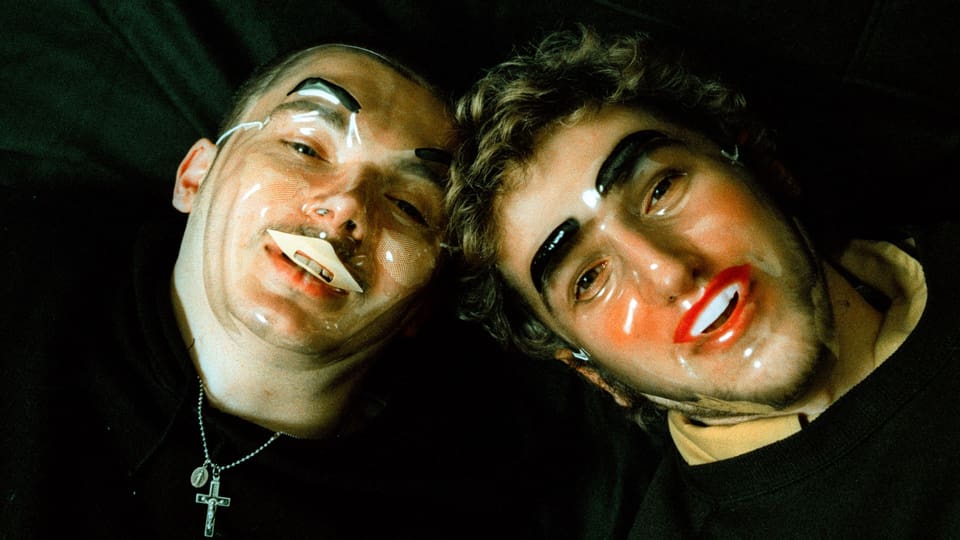Zwei Männer mit transparenten Masken