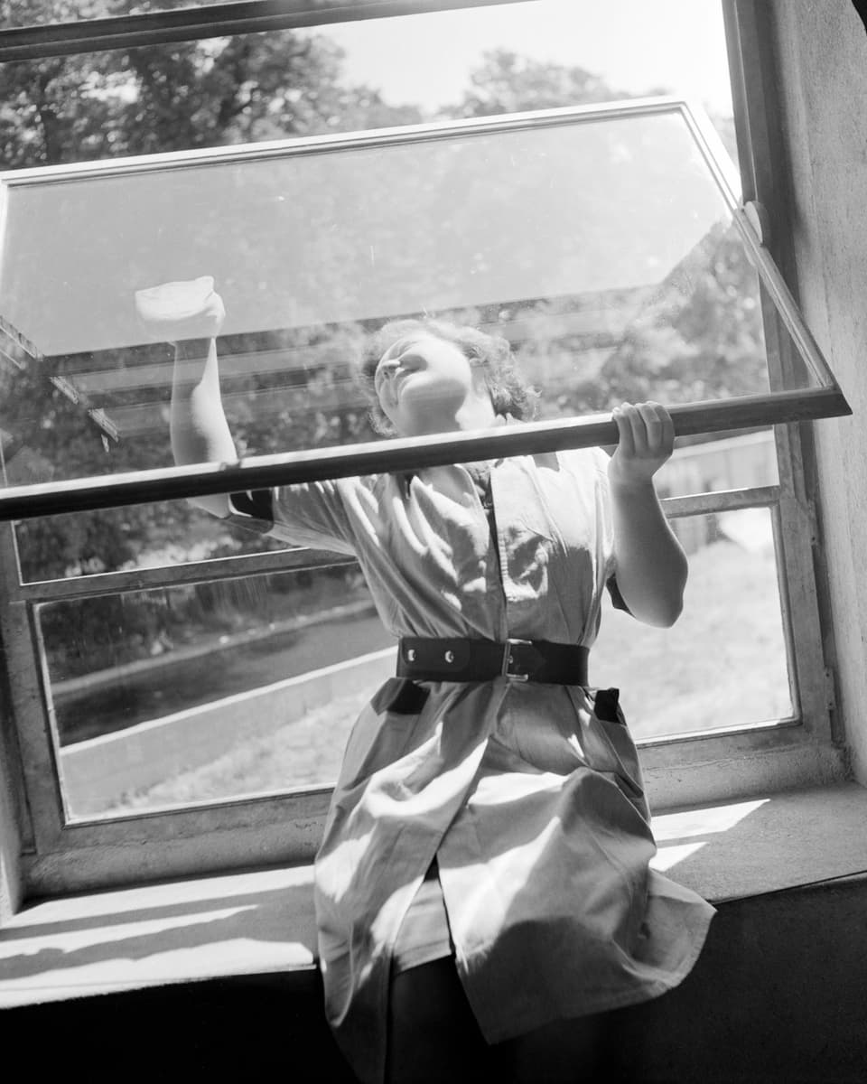 Eine Frau beim Fensterputzen.
