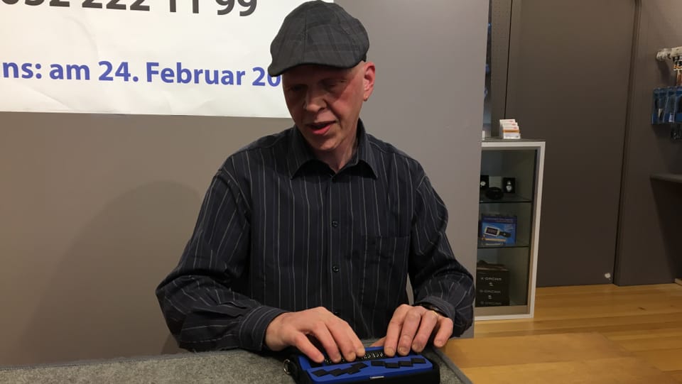 Stefan Hofmann sitzt vor der Braille-Tastatur
