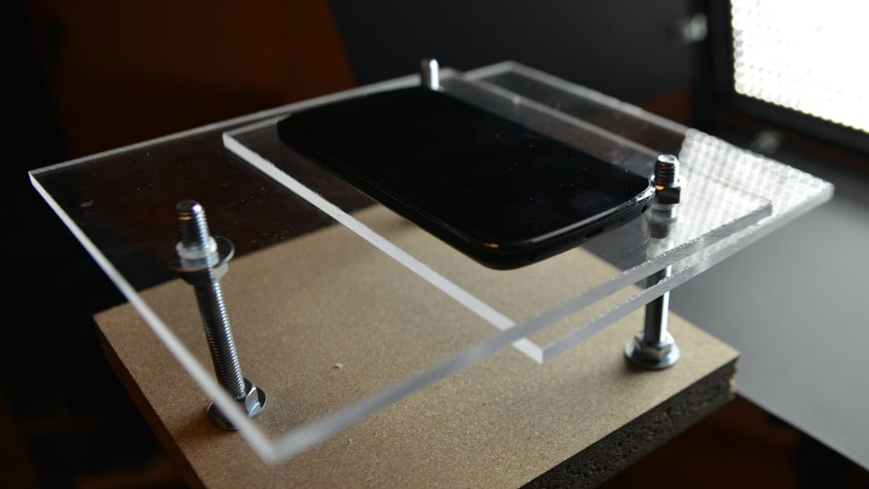 Smartphone auf einem Gestell mit Plexisglas