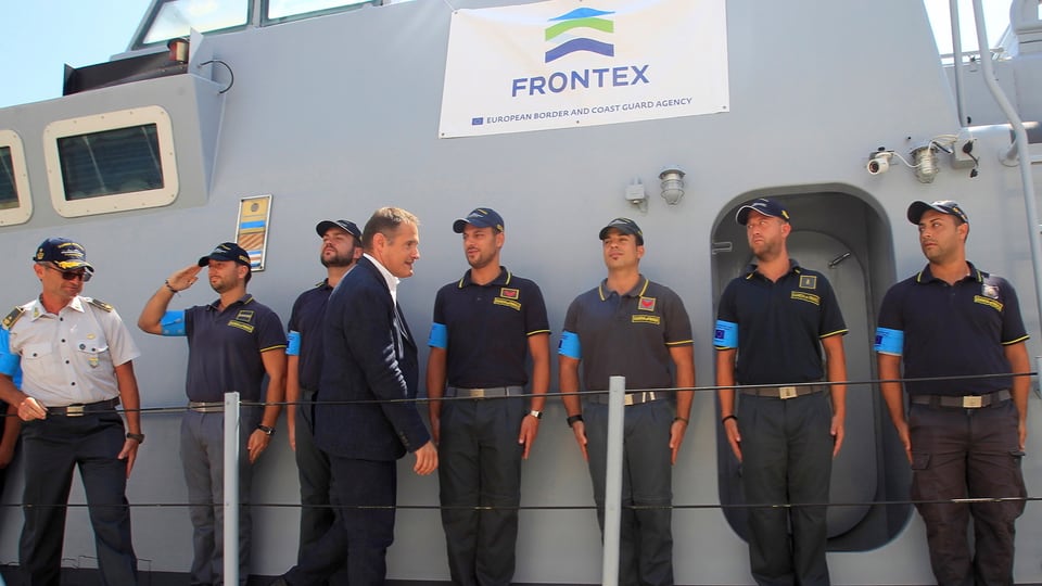 Grenzschutzbeamte der Frontex aufgereiht vor einer Wand.
