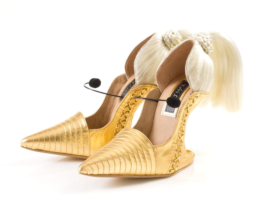 Goldene Schuhe mit blonden Haaren.