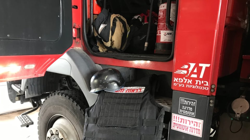 Ein Bild von einem Feuerwehrwagen, Helmen und kugelsicheren Westen