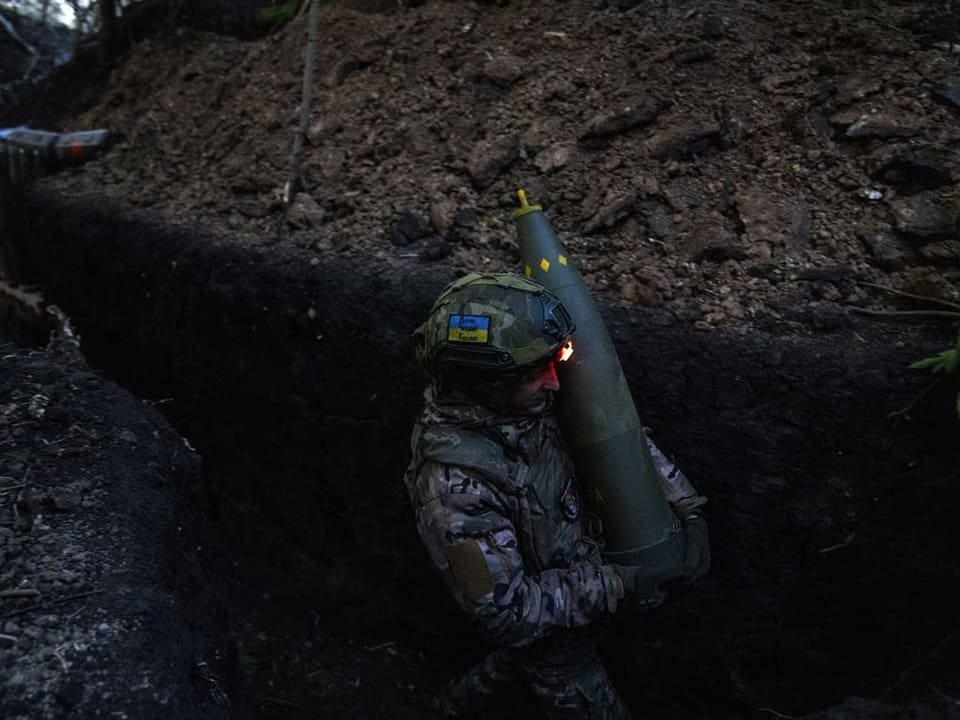 Ein ukrainischer Soldat trägt eine Granate.