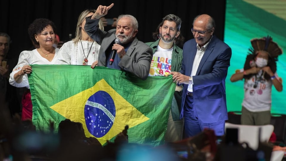 Lula spricht, Brasilienfahne und Anhängerinnen um ihn herum.