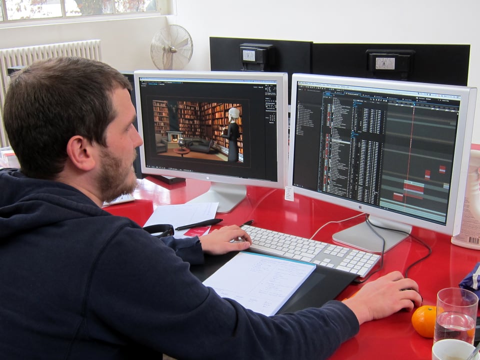Ein Mann sitzt am Computer, vor ihm zwei Bildschirme.