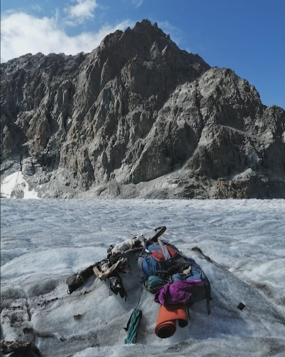 Auf dem Gletschereis liegen Überreste eines Menschen und Teile seiner Bergsteigerausrüstung.