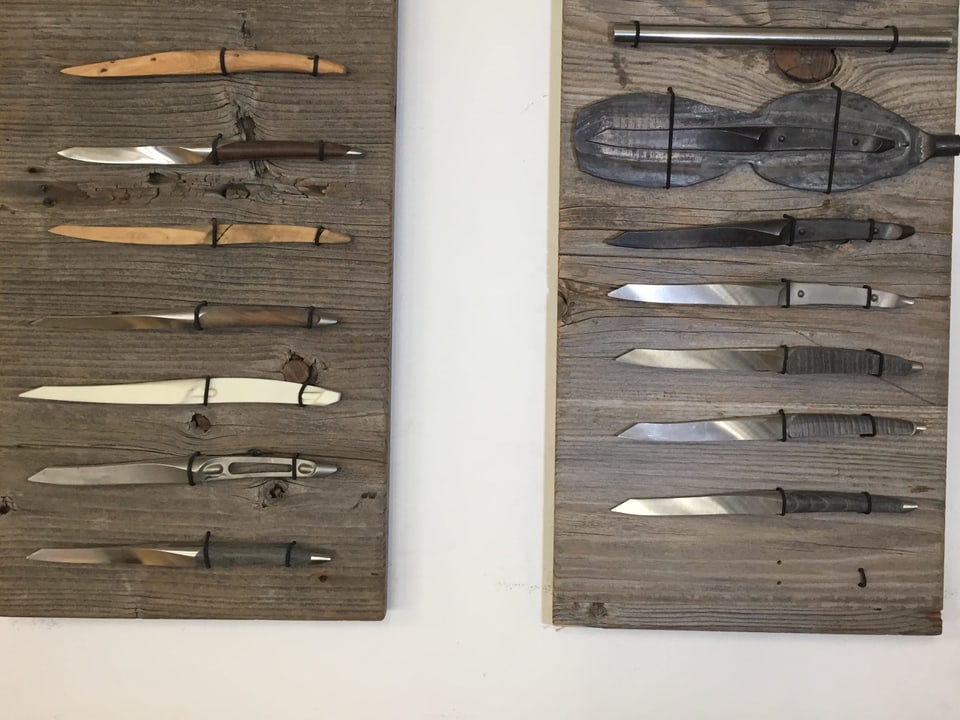 Rohlinge und Messer auf Holztafeln.