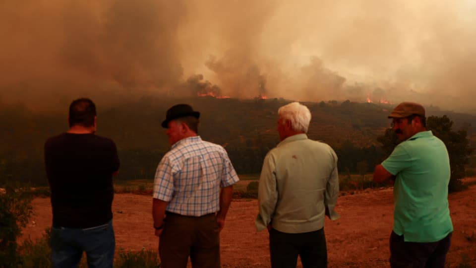 Menschen beobachten einen Waldbrand in Carrapichana