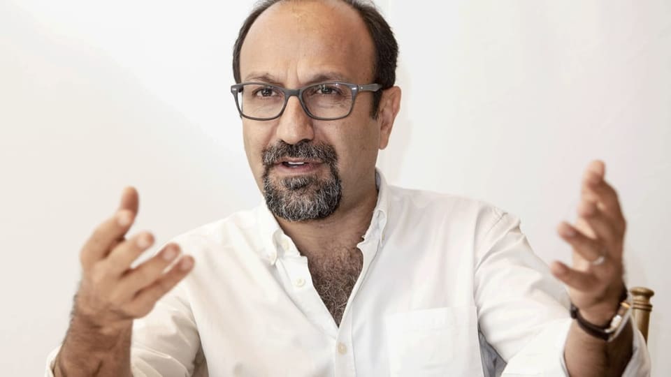 Ein Mann mit Brille und Hemd gestikuliert mit den Händen.