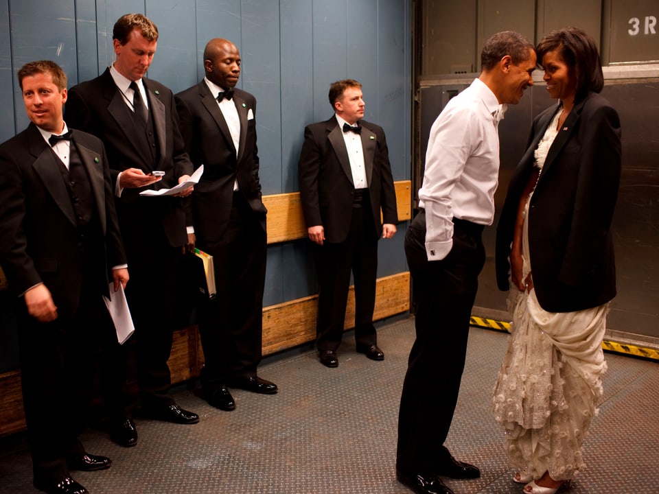Barack Obama und Michelle kuscheln in einem Lift, während seine Mitarbeiter diskret zur Seite sehen.