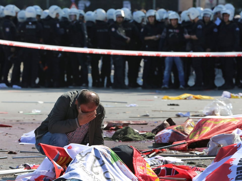 Ein Mann kauert am Boden und trauert um die getöteten Demonstranten. 