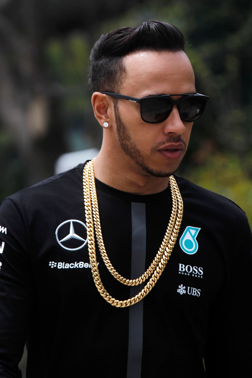 Um Lewis Hamiltons Hals hängt eine markante Goldkette.