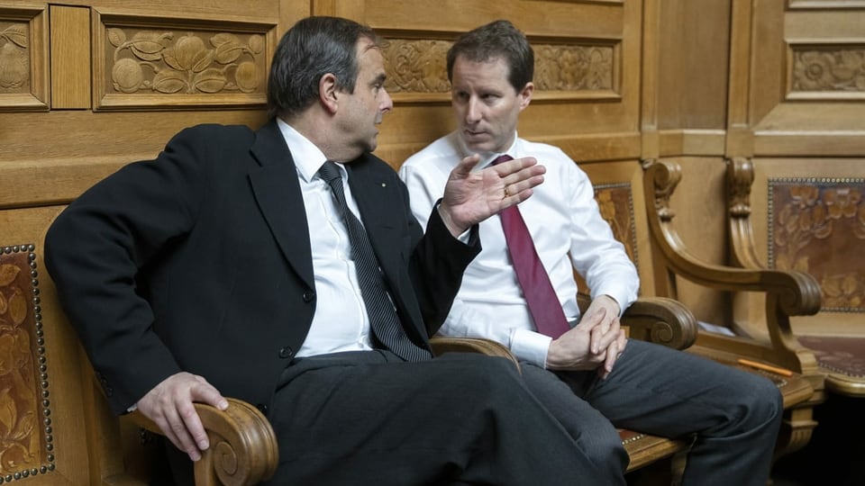 Pfister und Aeschi sitzen nebeneinader auf einer Bank im Nationalratssaal.