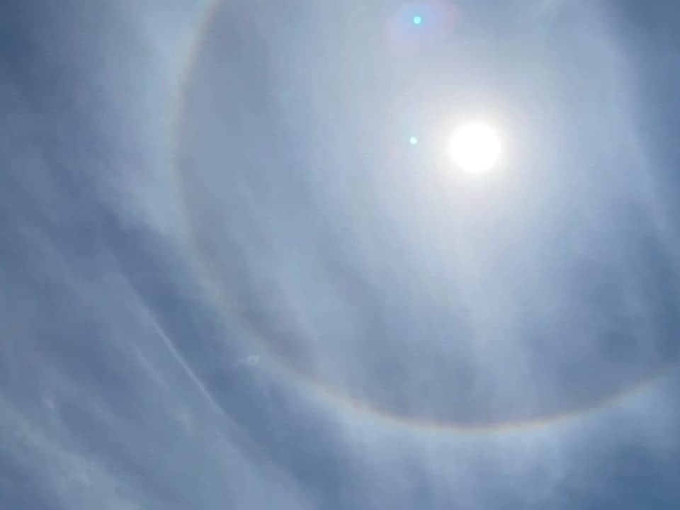 Regenbogen-Ring um die Sonne am milchigen Himmel