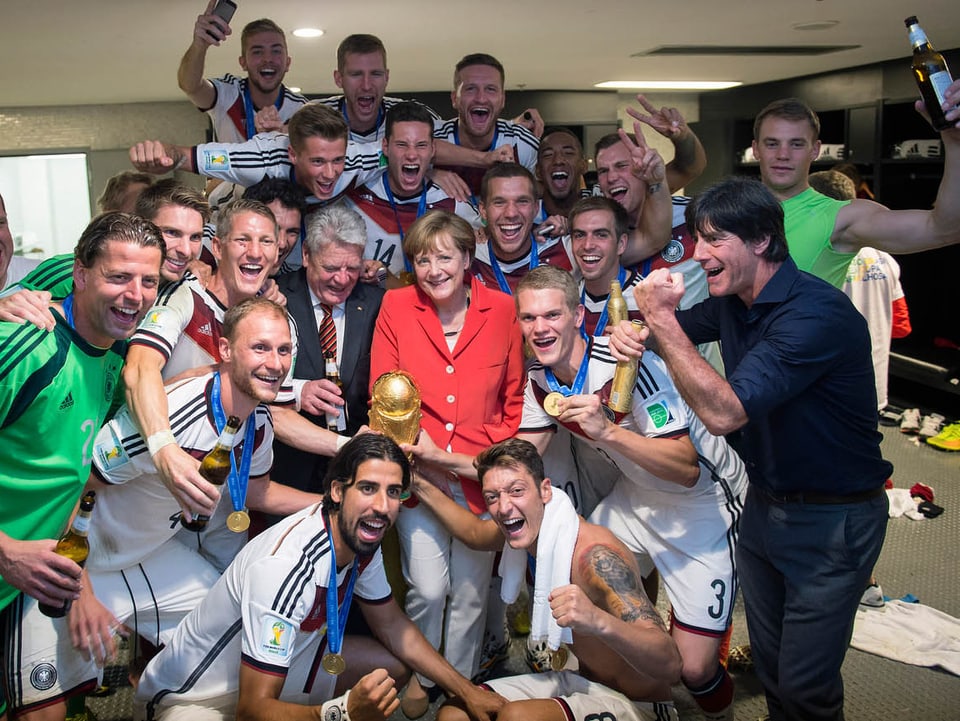 Angela Merkel mit der deutschen Mannschaft in der Kabine.