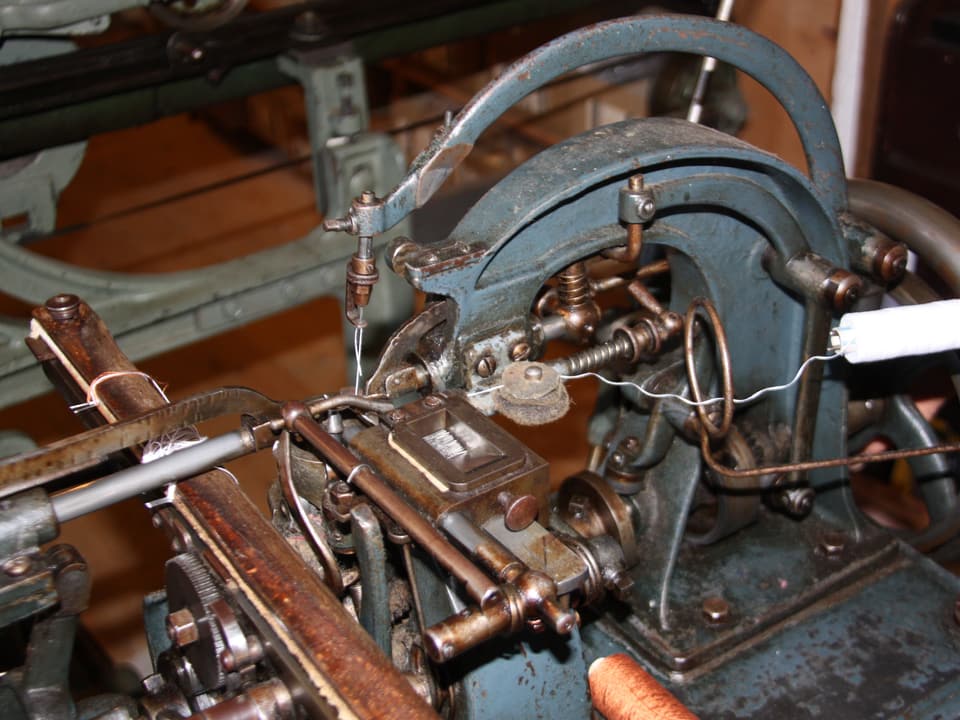 Eine antike Maschine mit einer kleinen Spule Faden.