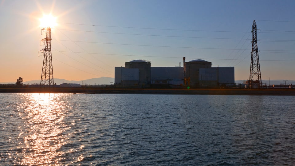 Die Sonne steht über dem Atomkraftwerk Fessenheim am Rhein.