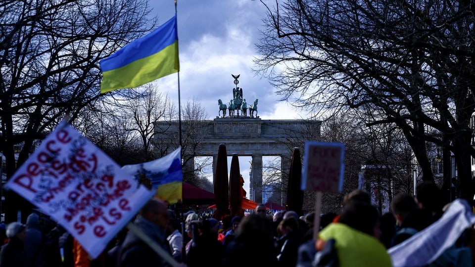 Menschenmassen und Ukraine-Flaggen vor dem Brandenburger Tor.