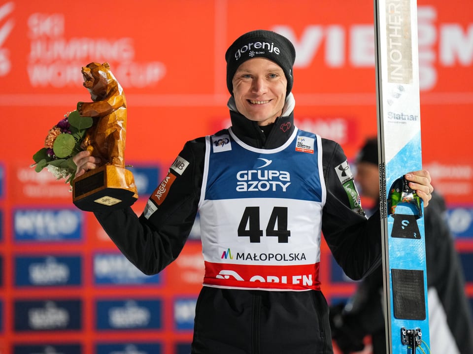 Anze Lanisek posiert mit seinen Skier und dem Preis für Rang 3.