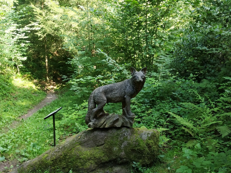 Wolf, geschnitzt aus Holz im Wald.