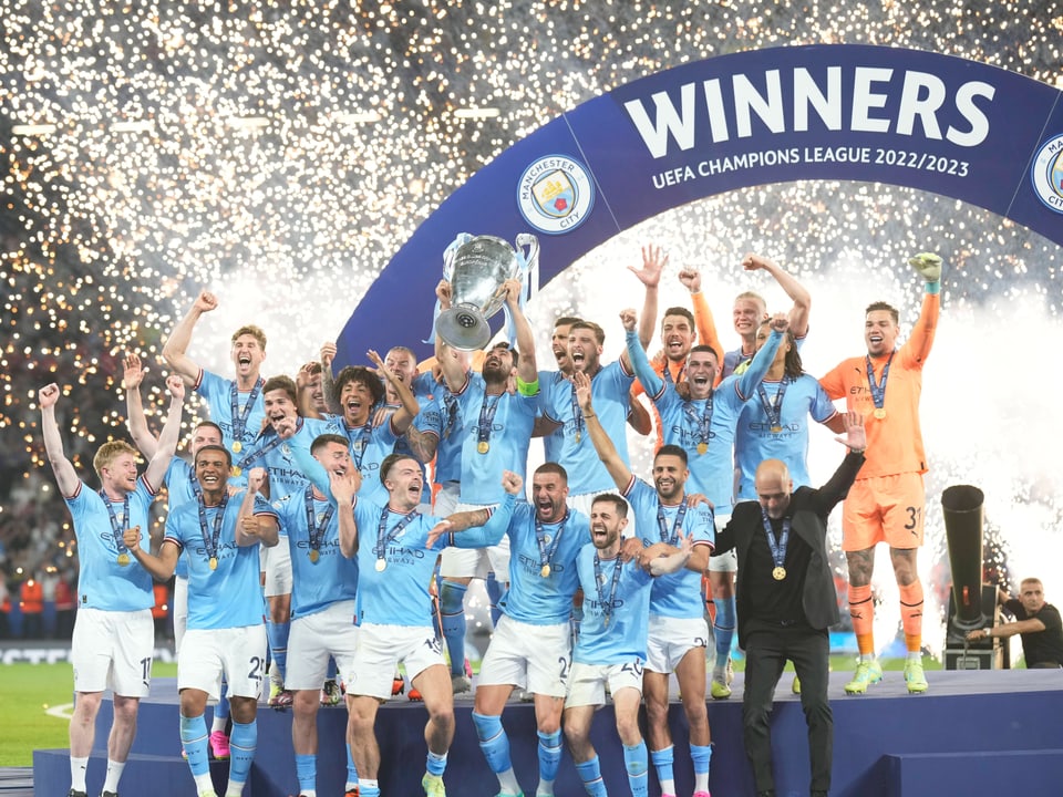Die Spieler Manchester Citys stemmen den Champions-League-Pokal in die Höhe. 