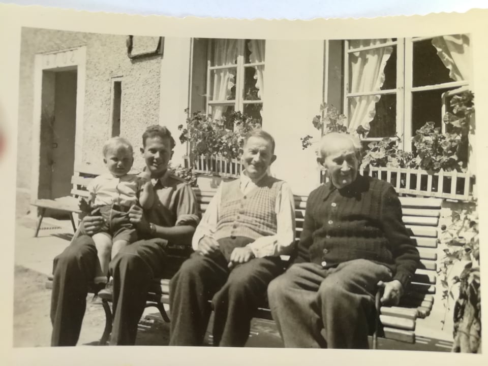 Altes Foto mit Menschen auf einer Bank.