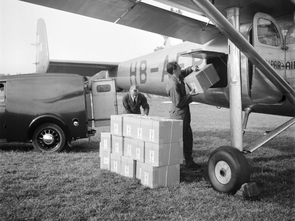 Männer laden Kisten in Flugzeug