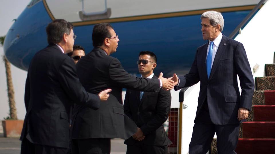 Kerry steigt aus einem Flugzeug und begrüsst einen ägyptischen Politiker.