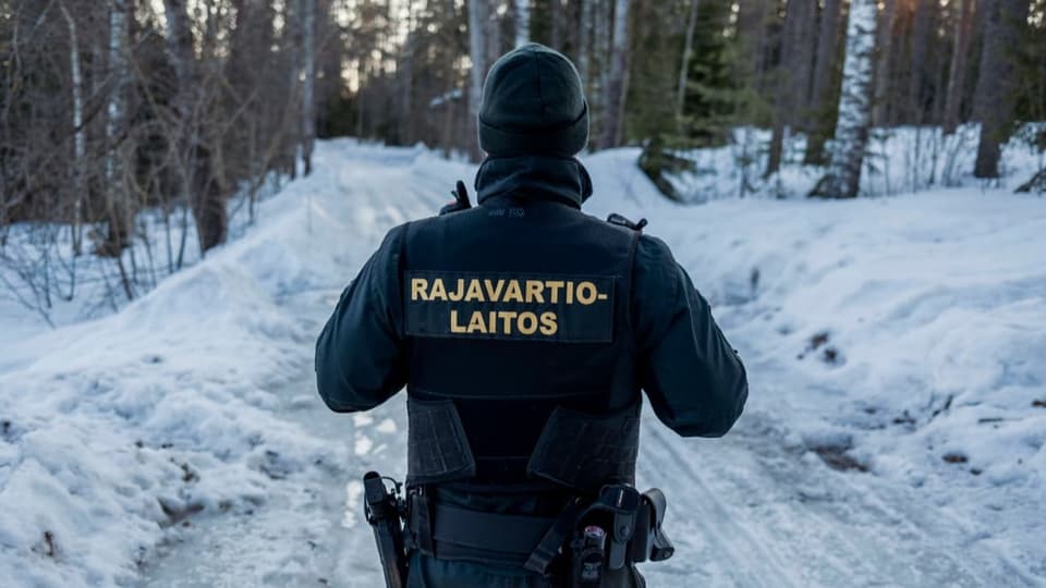 Ein finnischer Grenzwächter läuft durch den schneebedeckten Wald.