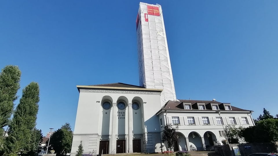 Kirche mit hohem, eingerüstetem Kirchturm.