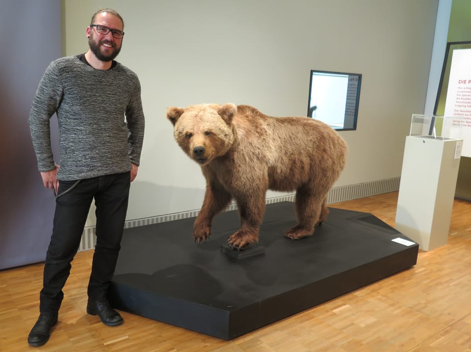Holger Frick steht vor einem ausgestopften Bären.