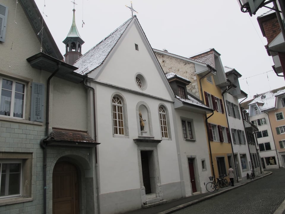 Kapelle in einer Altstadt, rundherum Häuser