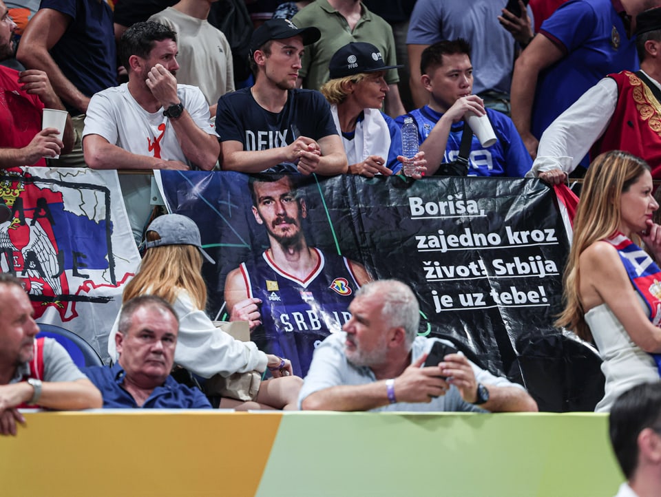 Serbische Fans während des Viertelfinalspiels mit einem Poster von Borisa Simanic.